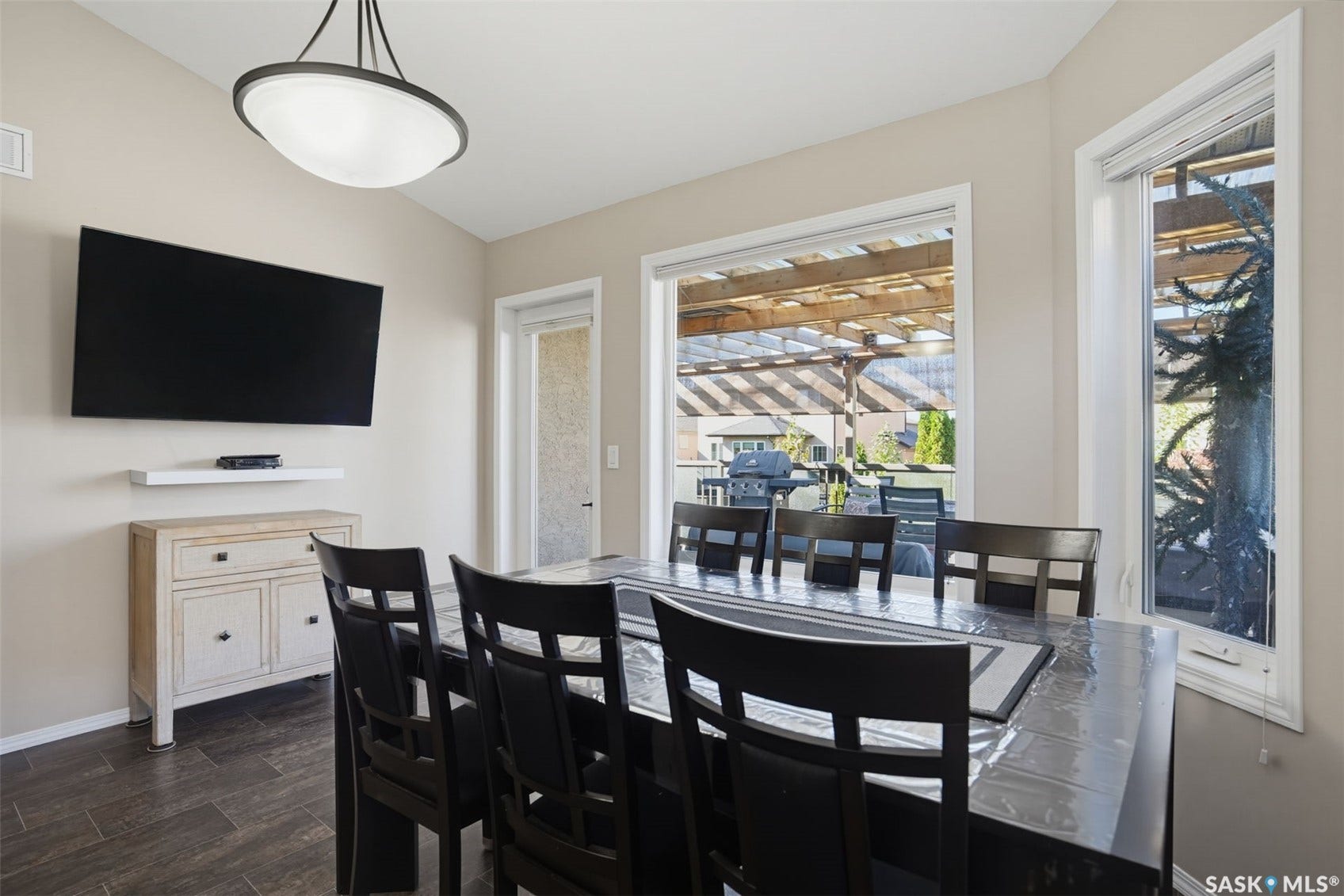 Recessed lighting fixture, light-toned wall paint, dark wood-finish flooring, white trim windows, and exterior covered patio