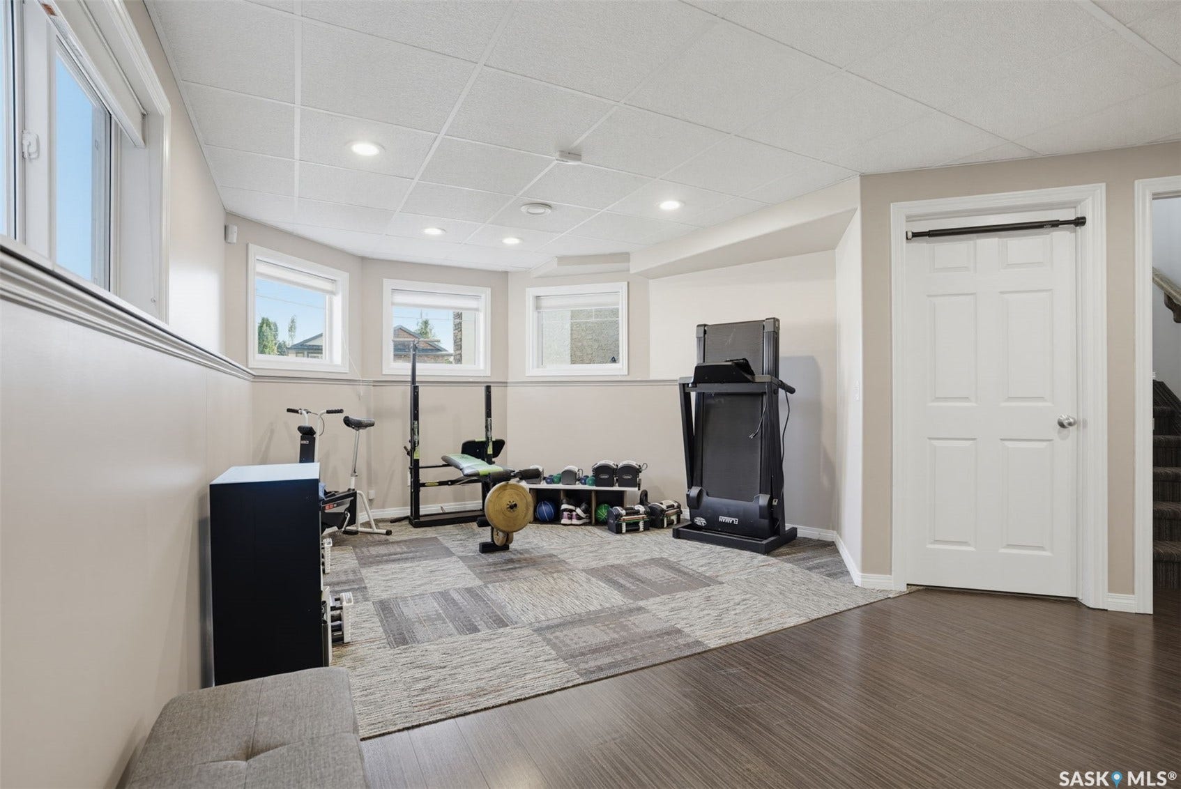 Recessed lighting, light-toned walls, multiple windows, wood-finish flooring, and carpet tile flooring