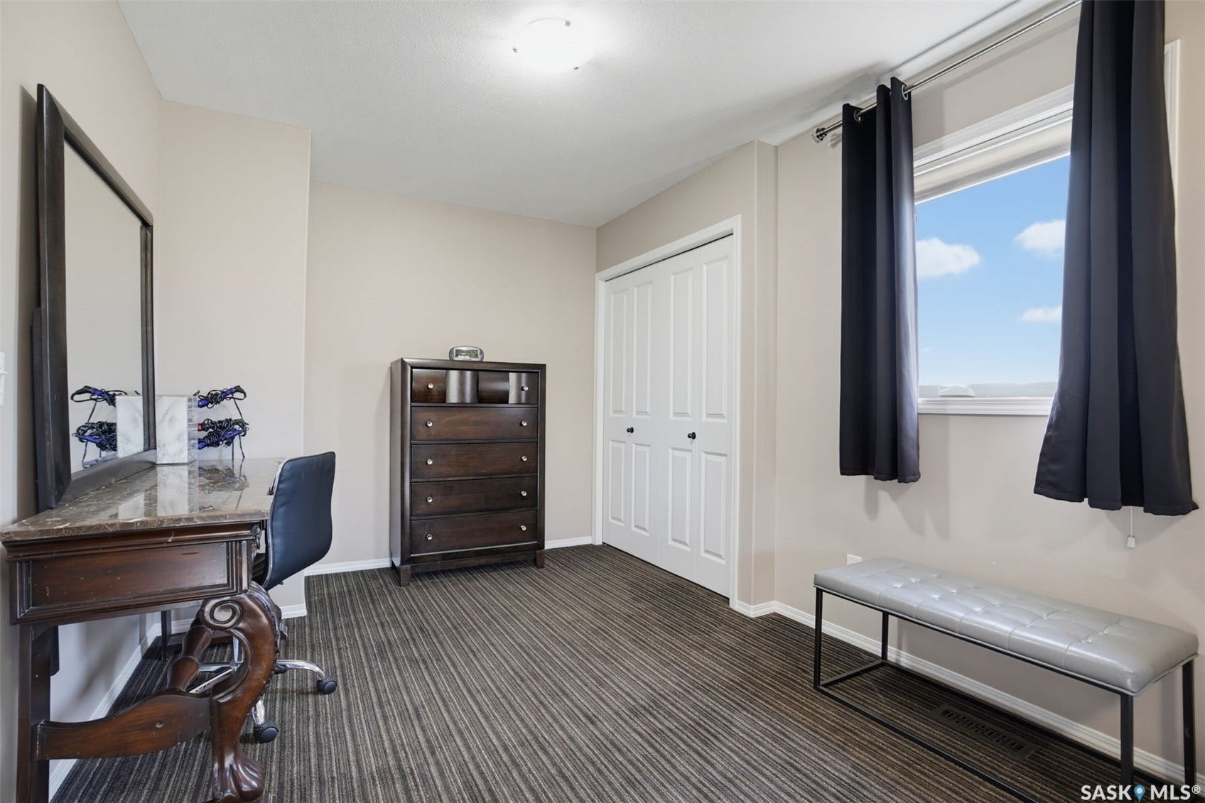 Striped plank flooring, light neutral wall paint, overhead lighting, white trim, and a window with natural light