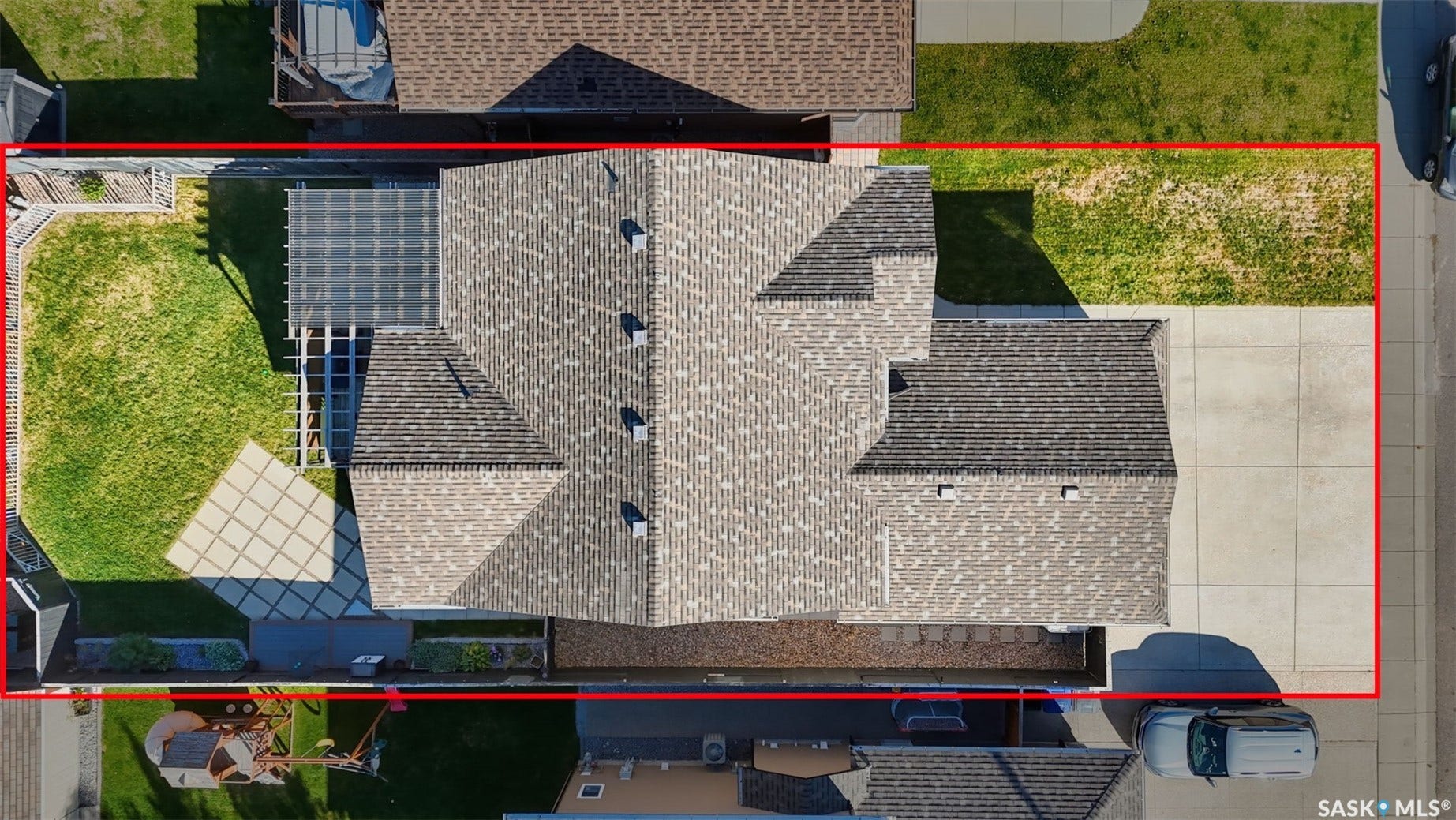 Shingle roof residence featuring a rear yard with green space, a pergola, and a patterned patio