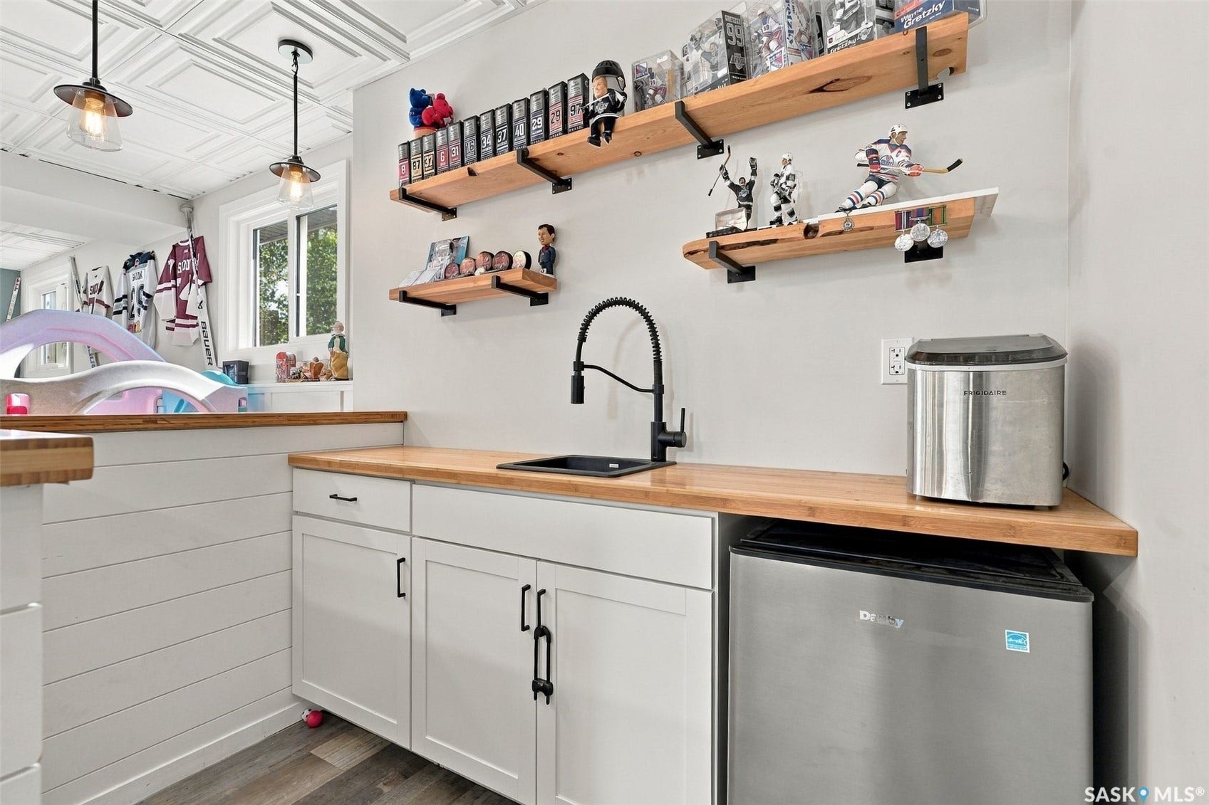 Custom built-in cabinetry with white shaker-style doors, wood-finish countertops, and matte black hardware