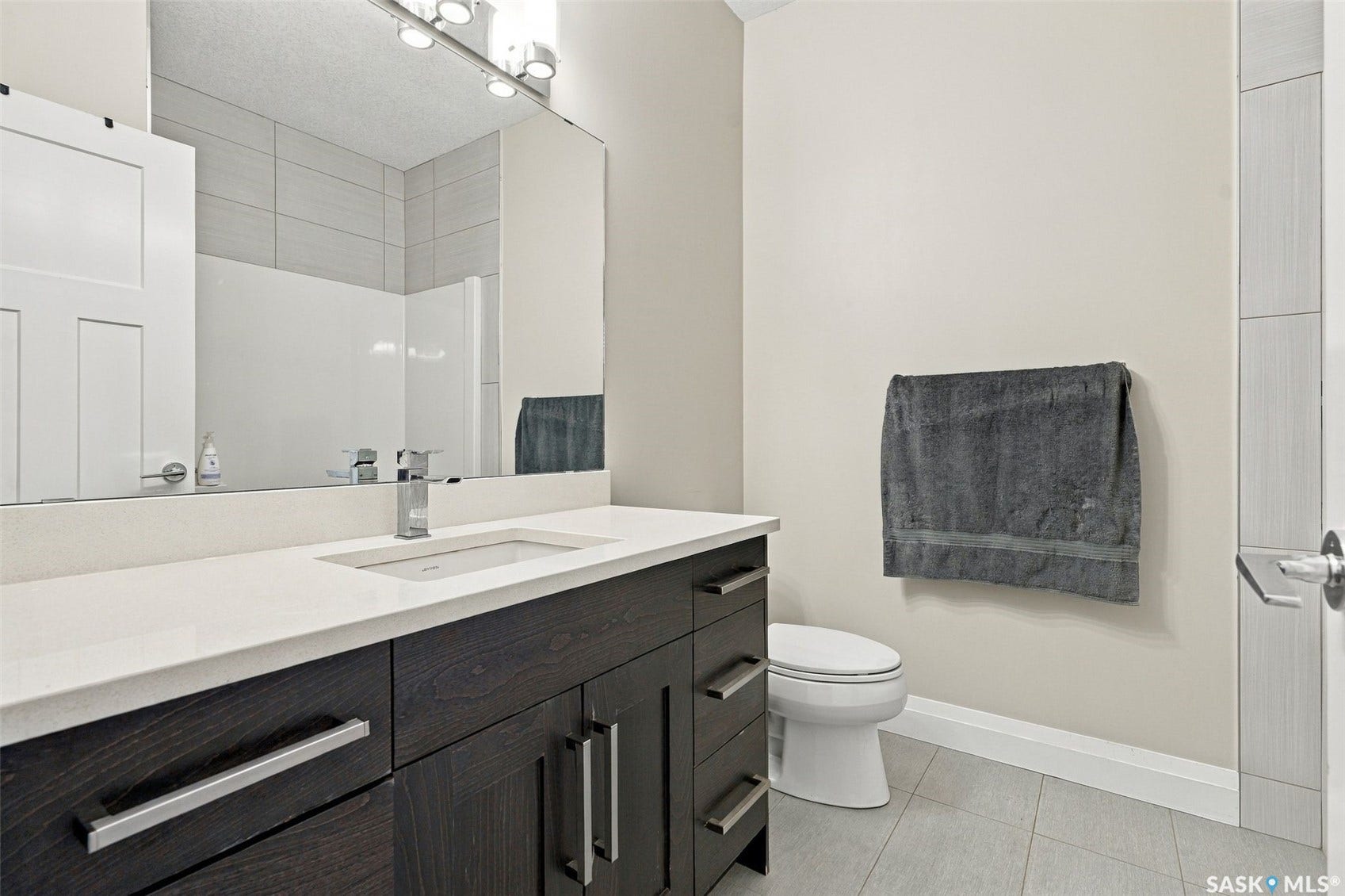 Dark wood-finish vanity with a white countertop and integrated sink