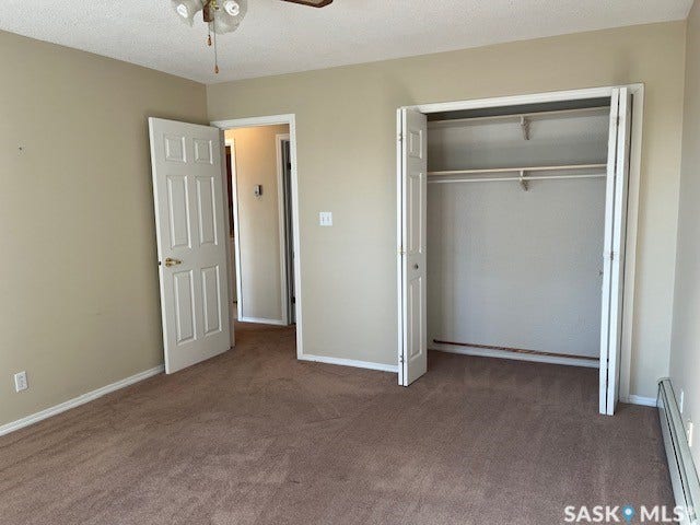 Carpeted room with a ceiling fan, a bi-fold closet, and a light-colored wall finish