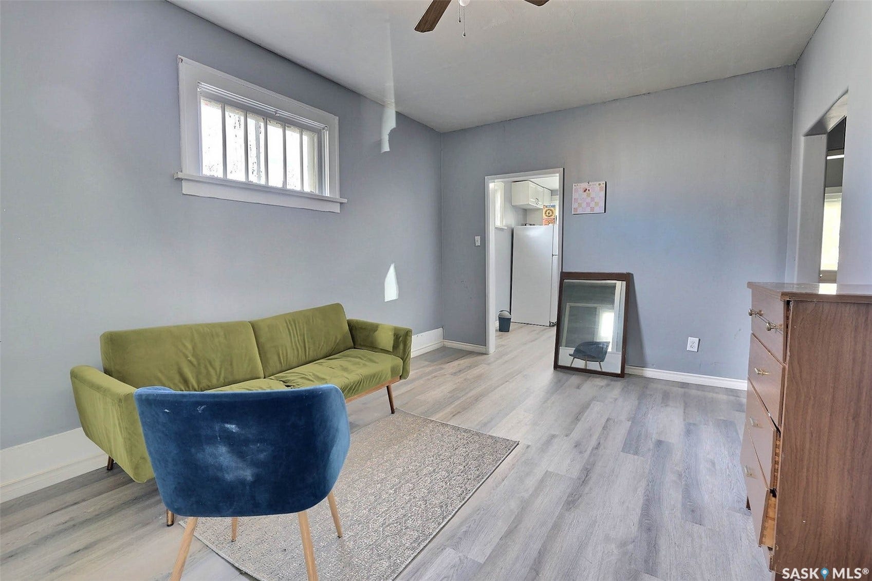 Hardwood-look flooring, light gray wall color, white trim, and a ceiling fan