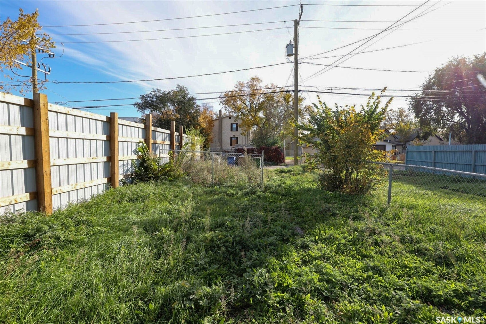 Enclosed outdoor space featuring a corrugated metal fence with wood posts