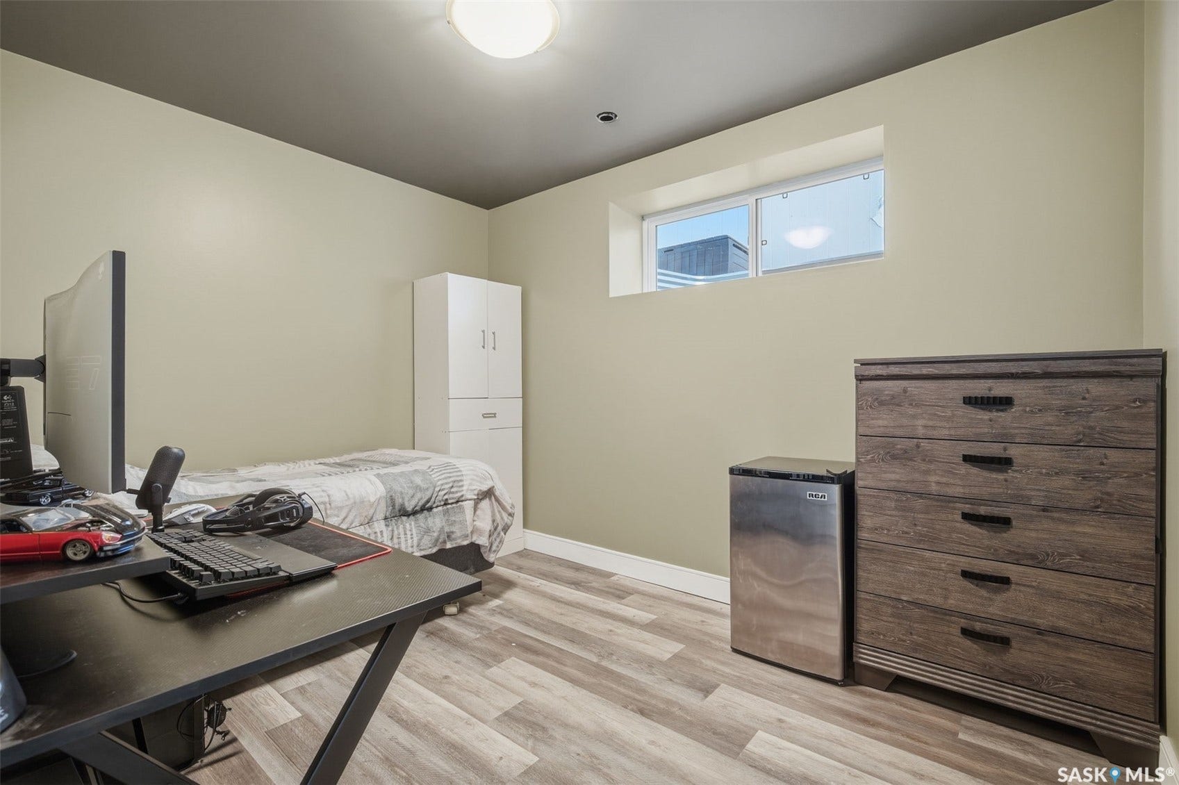 Wood-finish flooring, light-colored walls, and a window with natural light
