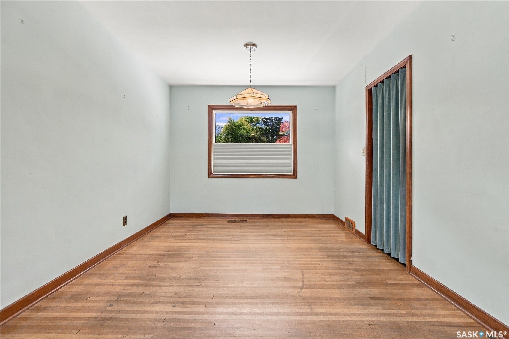 2727 Assiniboine Avenue, Regina SK S4S 1C7 Hardwood flooring, window with wood trim, ceiling-mounted light fixture, and light-colored walls