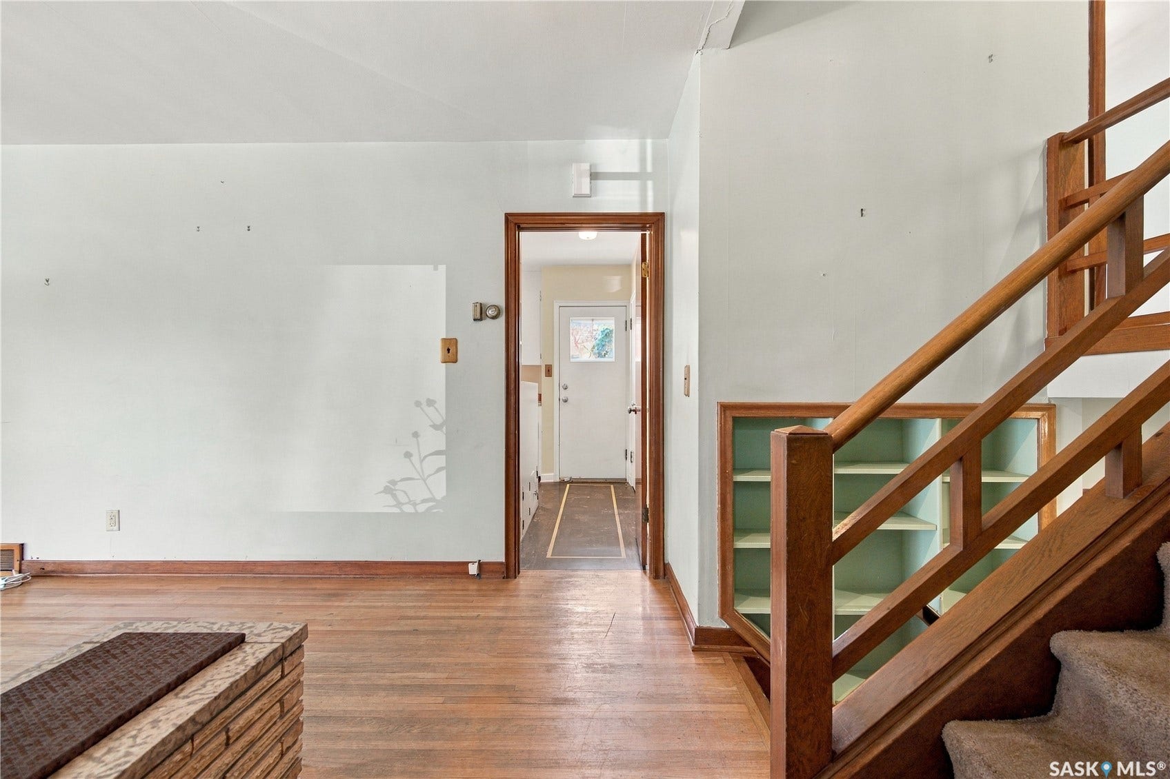 2727 Assiniboine Avenue, Regina SK S4S 1C7 Wood-finish flooring, built-in shelving, and a wood staircase with carpeted treads