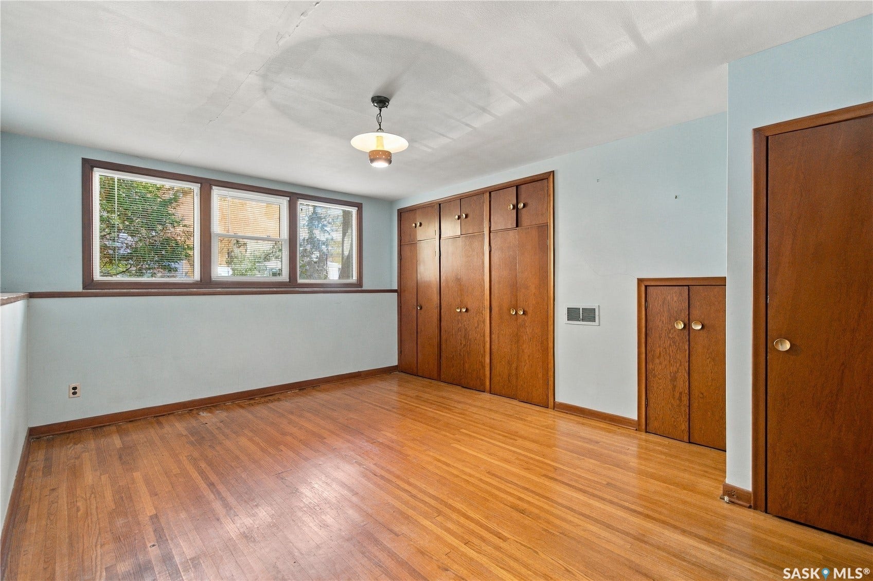 2727 Assiniboine Avenue, Regina SK S4S 1C7 Hardwood flooring, multiple windows, built-in storage, and a ceiling-mounted light fixture
