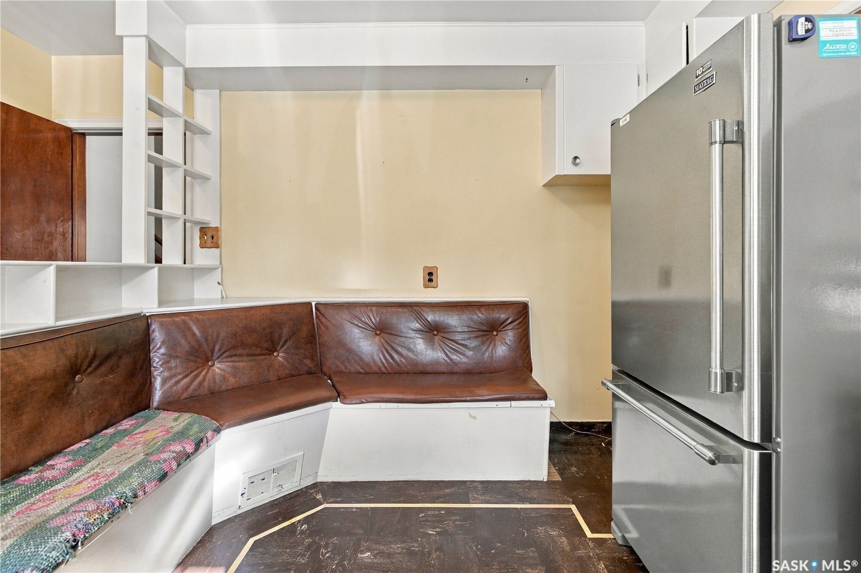 2727 Assiniboine Avenue, Regina SK S4S 1C7 Built-in bench seating with brown upholstery, stainless steel refrigerator, white built-in shelving, and a small upper cabinet