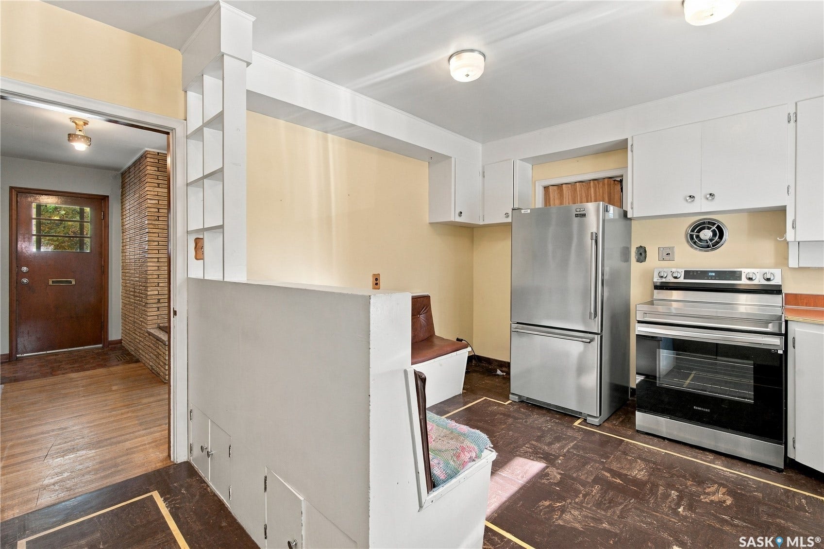 2727 Assiniboine Avenue, Regina SK S4S 1C7 Kitchen area featuring stainless steel refrigerator and range, white cabinetry, and built-in shelving