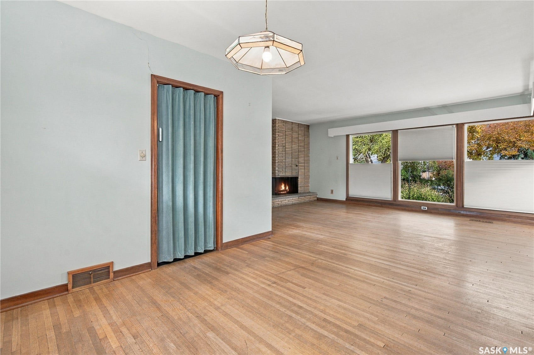 2727 Assiniboine Avenue, Regina SK S4S 1C7 Hardwood flooring, brick fireplace, expansive window bank, accordion door, ceiling-mounted light fixture