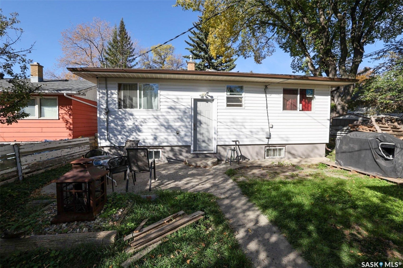 1021 Campbell Street, Regina SK S4T 5P5 Rear exterior featuring white horizontal siding, a concrete patio, and a grass lawn