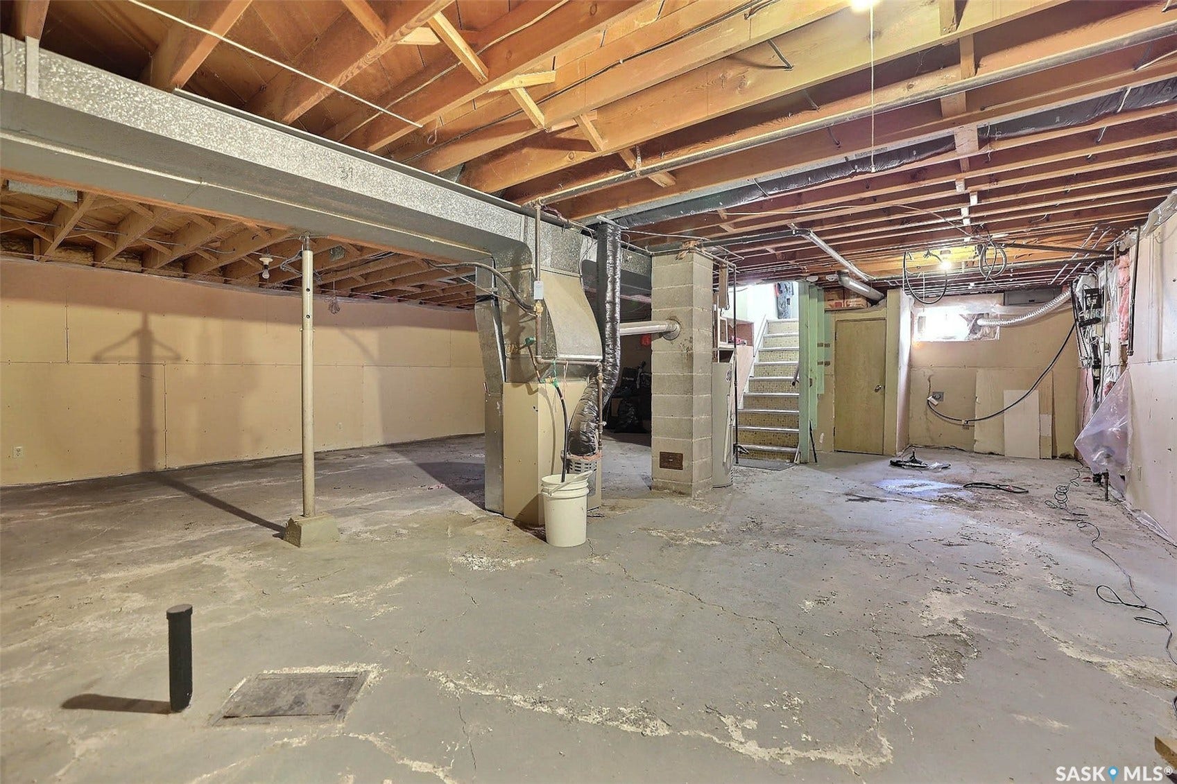 1021 Campbell Street, Regina SK S4T 5P5 Unfinished basement with exposed ceiling joists, concrete flooring, and visible structural beams
