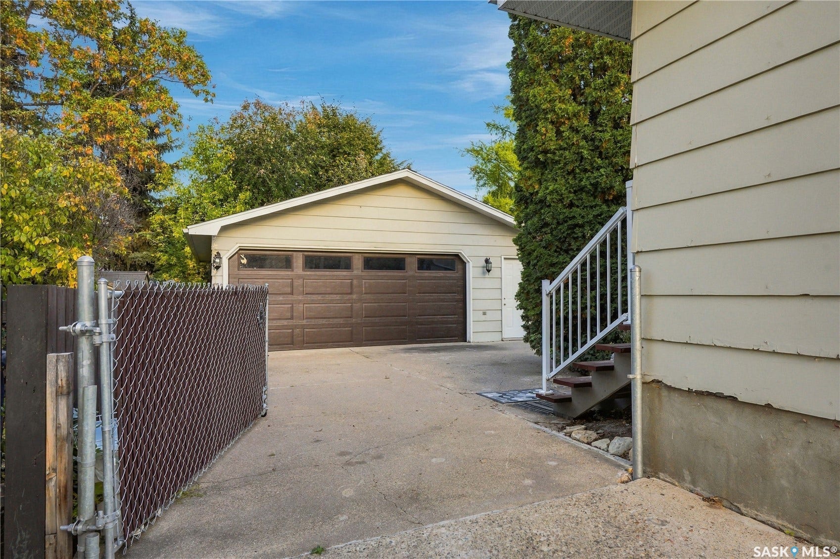 Swinging chain link gate leading to back yard and garage
