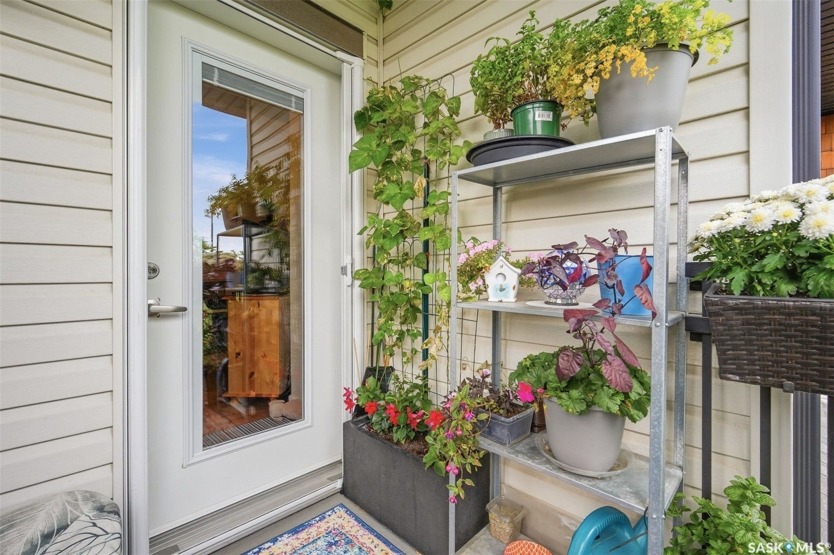 Exterior patio door with full-lite glass panel, durable vinyl siding, and metal shelving