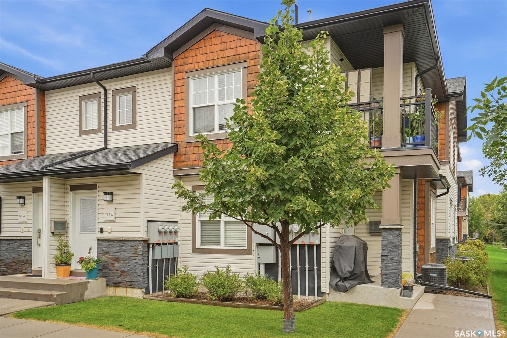 Multi-level townhome featuring a balcony with metal railing, siding and shingle exterior accents, and a covered entry