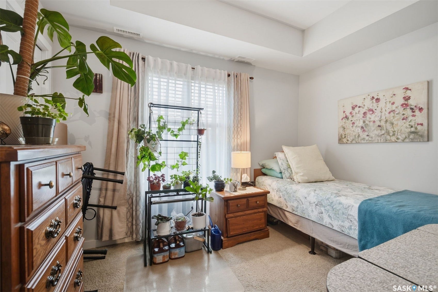 Tray ceiling, window with white blinds, wood-finish flooring, and white walls