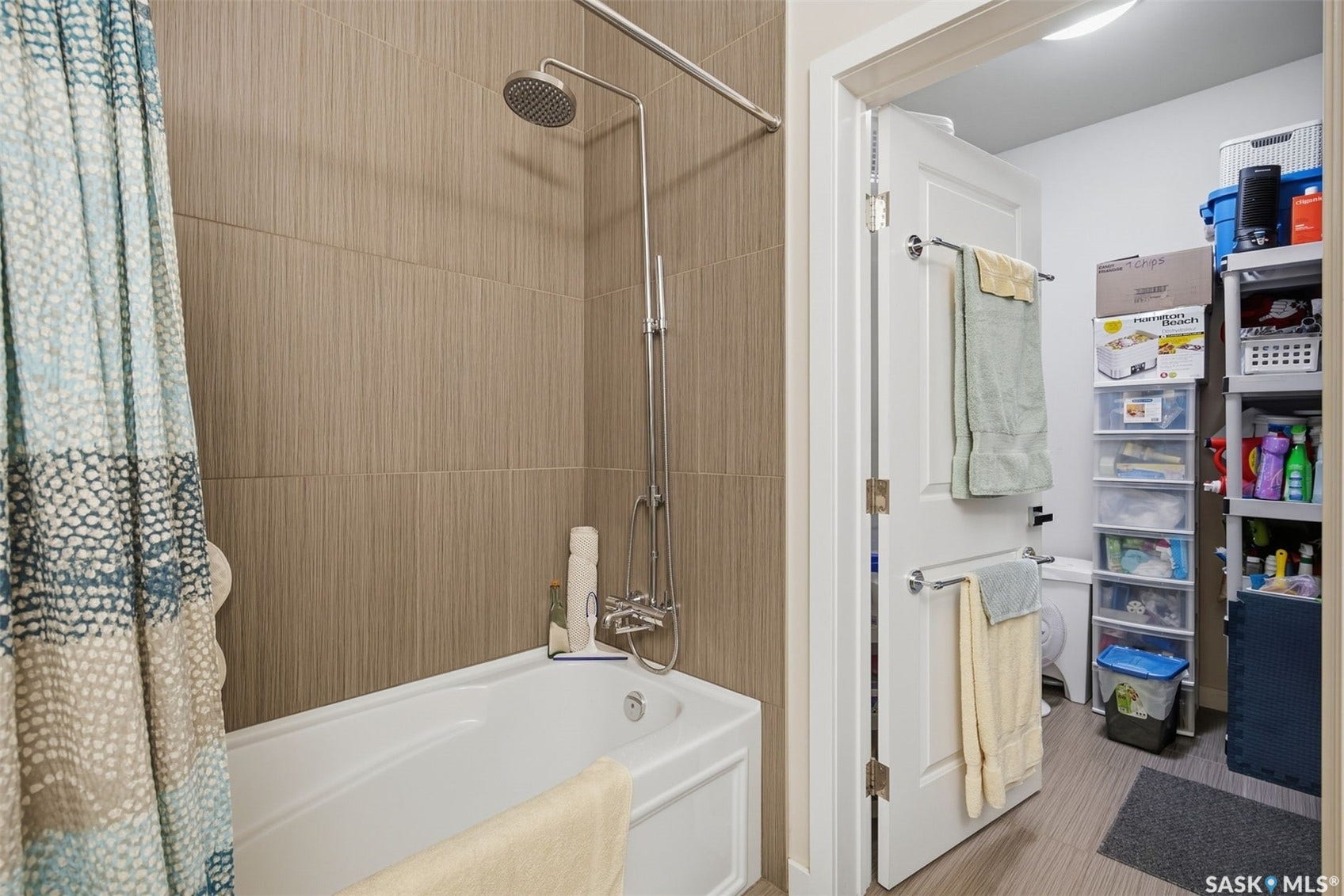 Tub/shower combination featuring a rainfall showerhead and wall-mounted controls