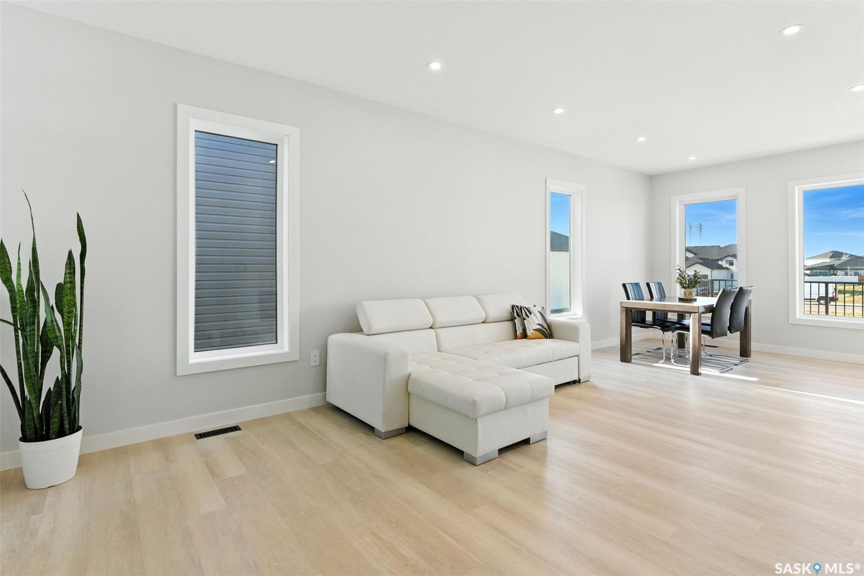Recessed lighting, light-toned wood-finish flooring, and multiple windows
