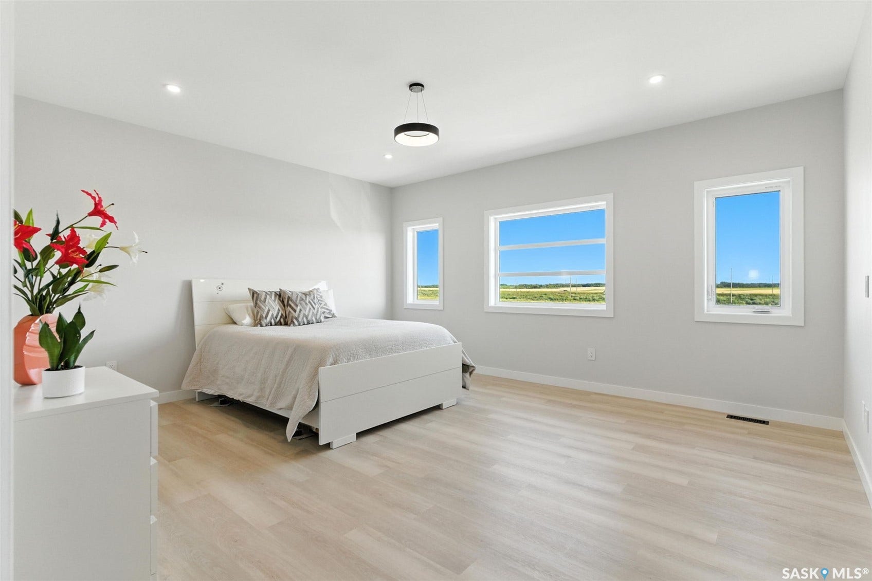 Recessed lighting, light wood-finish flooring, multiple windows, and a modern ceiling fixture