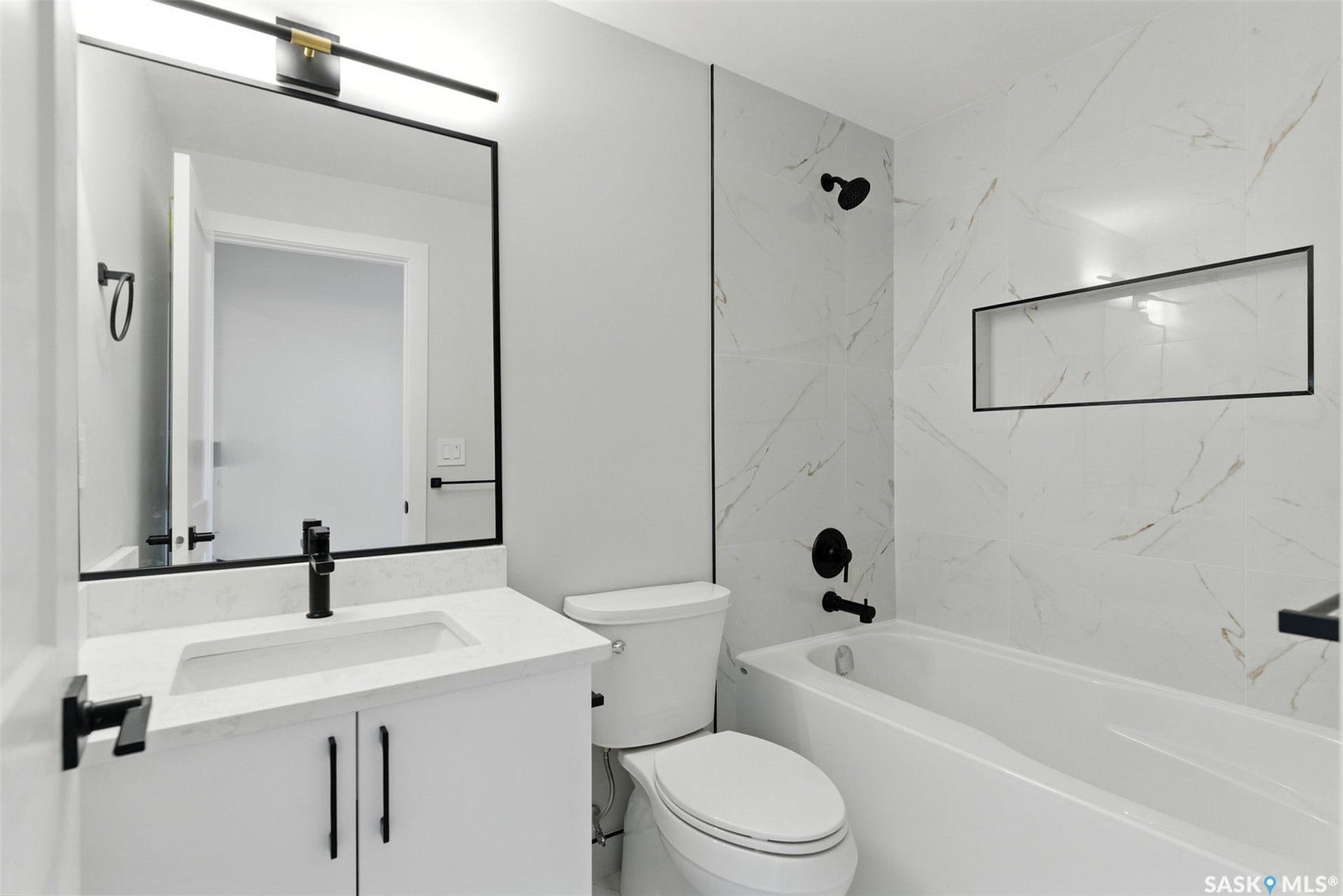White vanity with a rectangular undermount sink and stone-finish countertop