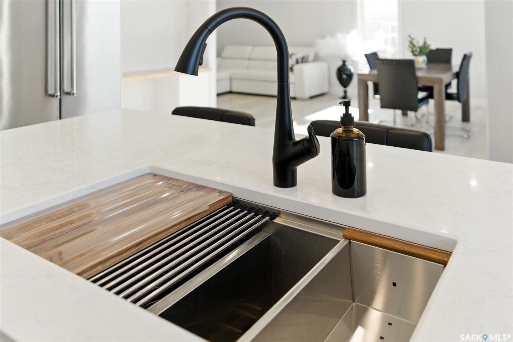 Integrated kitchen sink featuring a matte black faucet, custom cutting board, and stainless steel basin