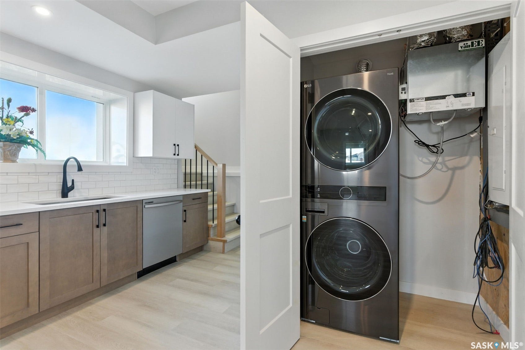 Kitchenette with light wood-finish flooring, white subway tile backsplash, white countertops, and a stainless steel dishwasher