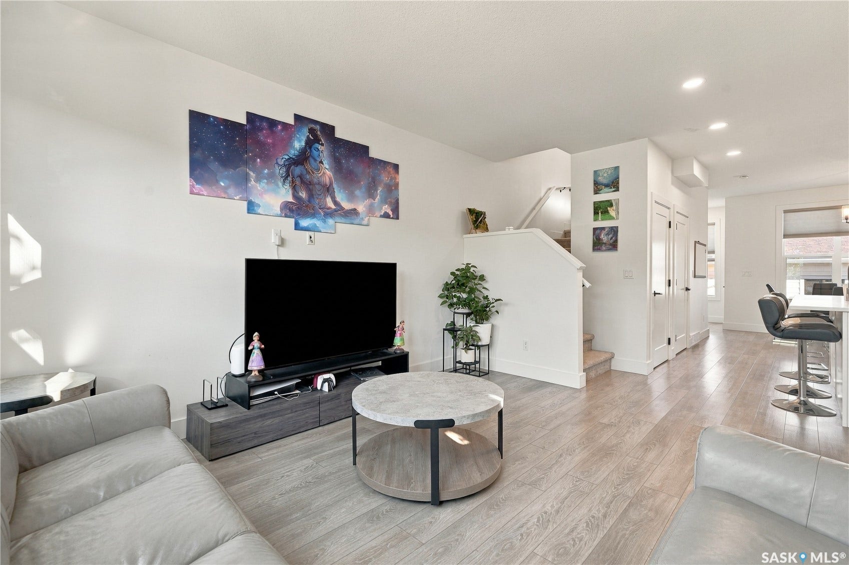 Open-concept living area featuring wood-finish flooring, recessed lighting, and a neutral color palette