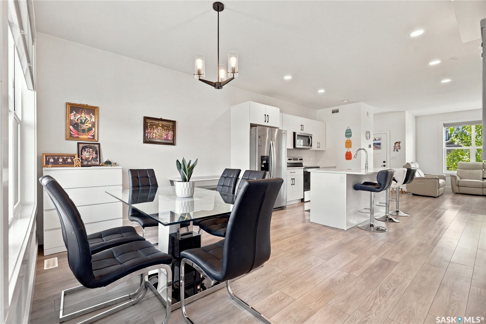 Open-concept living space featuring wood-finish flooring, recessed lighting, and a modern kitchen
