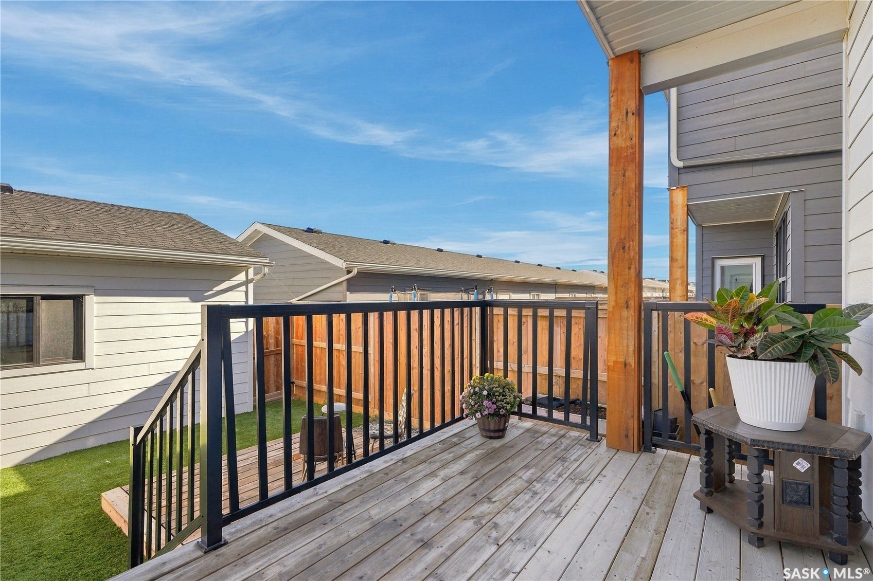 Wooden deck with black metal railing and exposed wood support beams