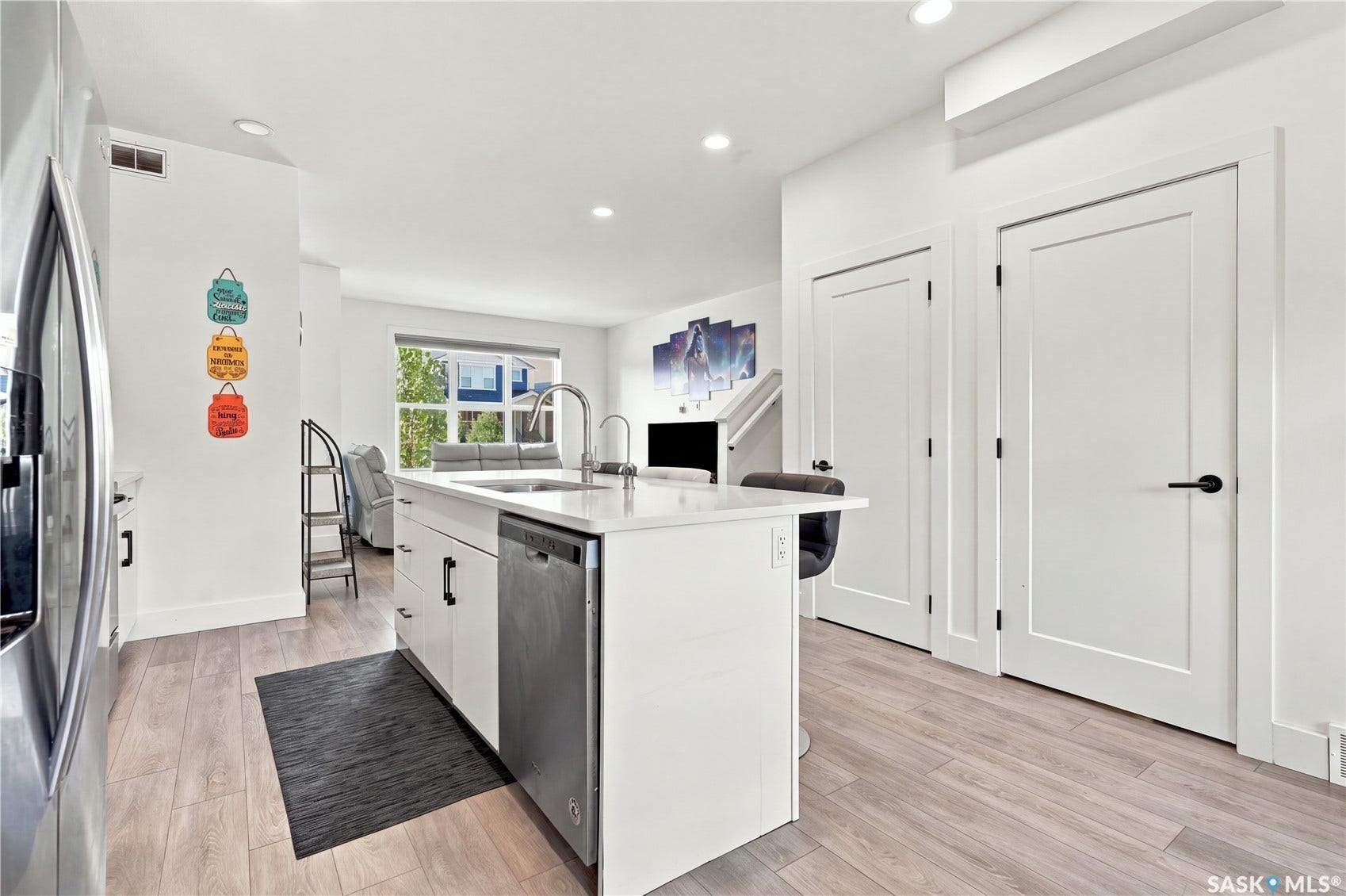 Kitchen island with a stainless steel sink, a pull-down faucet, and an integrated dishwasher