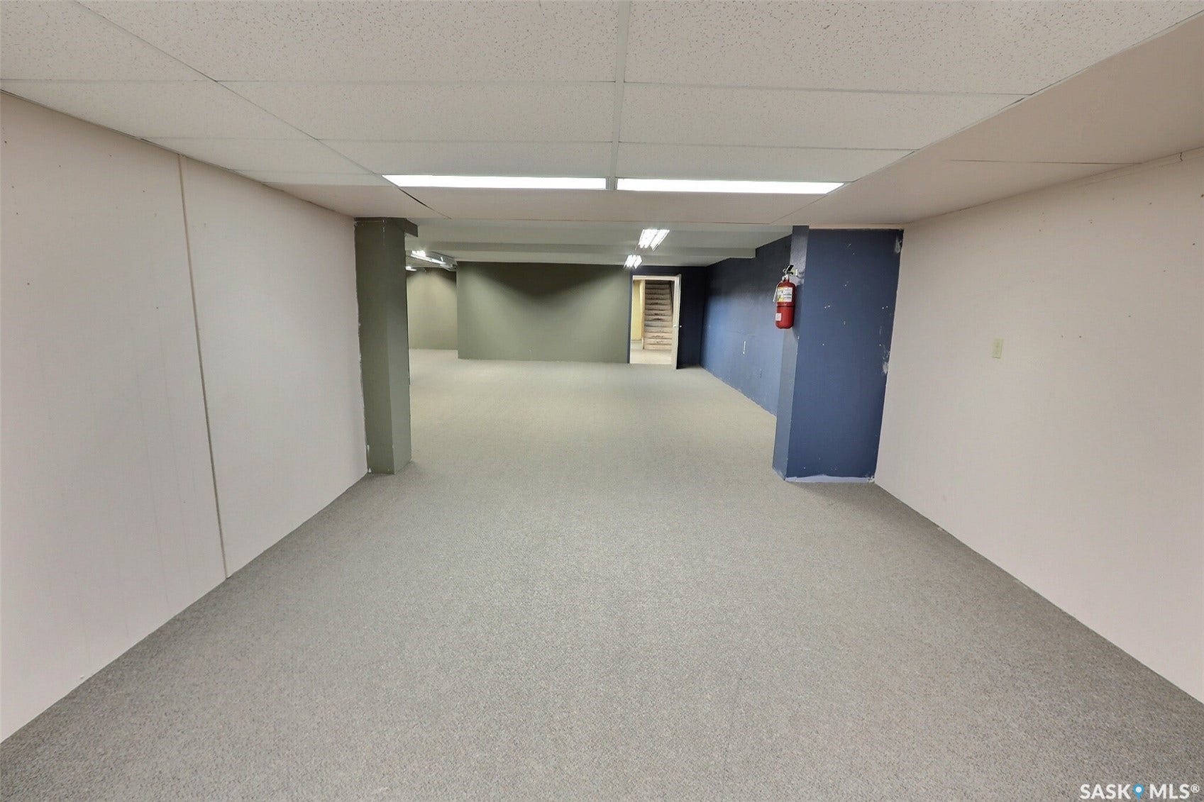 Expansive room featuring light-toned carpeting and overhead fluorescent lighting