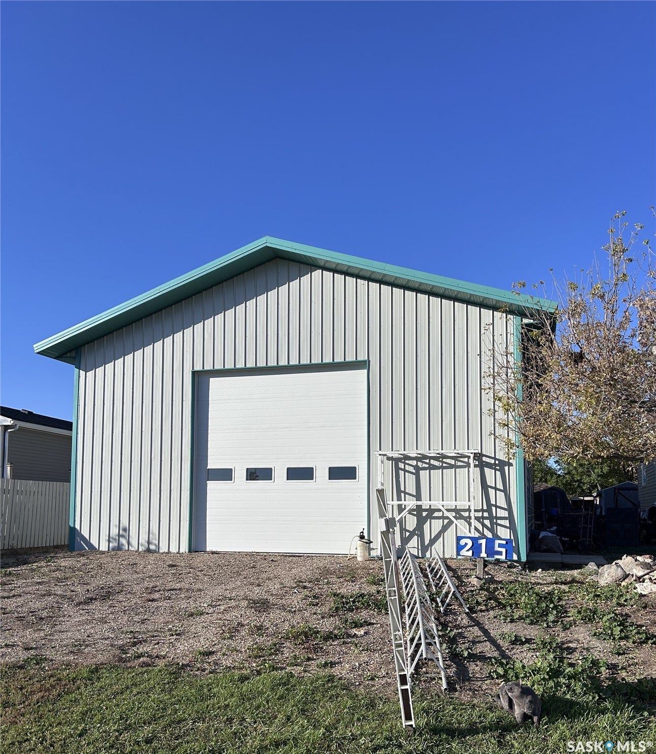 207 1st Street, North Portal SK S0C 1W0 Metal-clad utility building featuring a white garage door with rectangular window panels