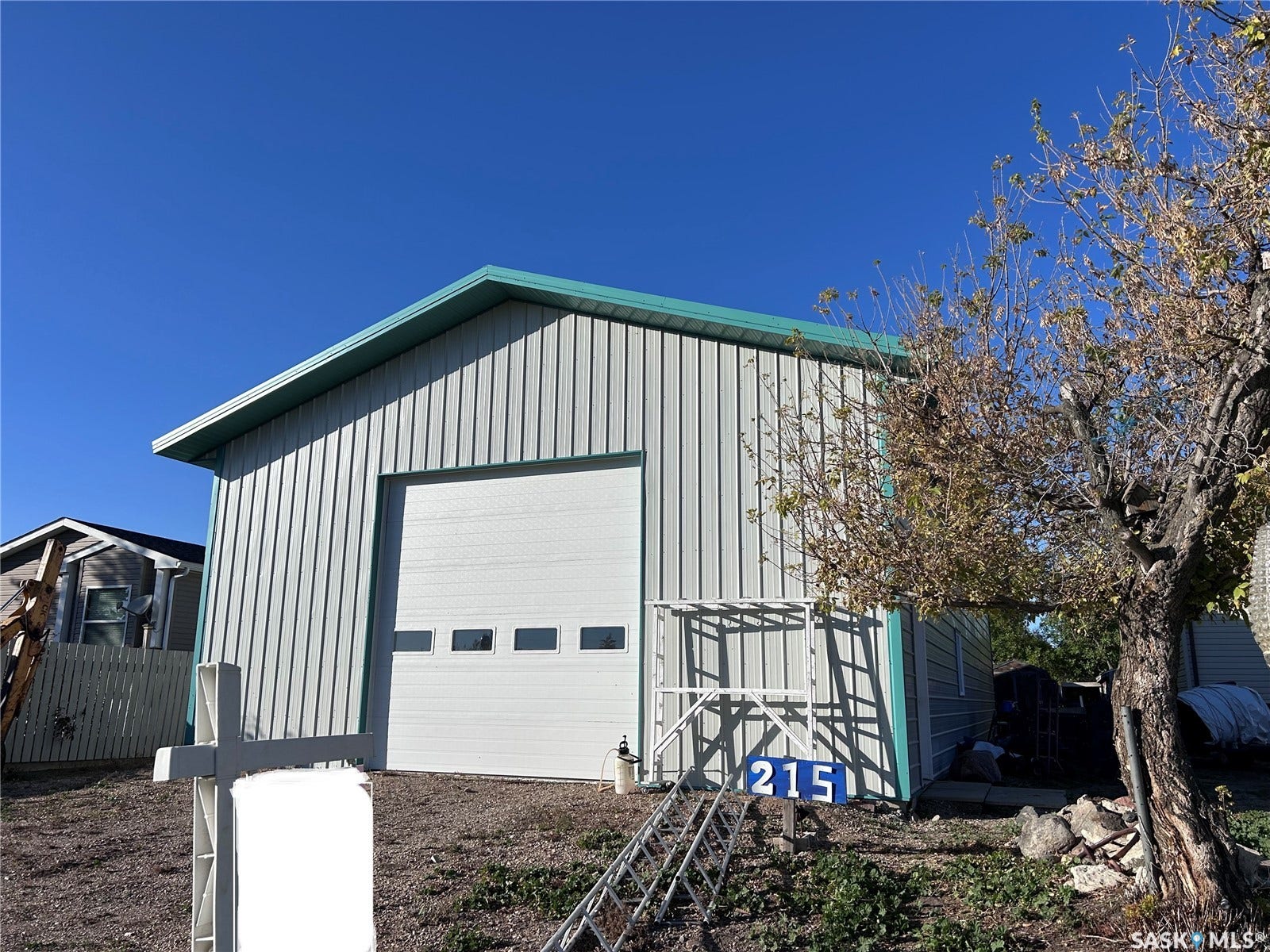 207 1st Street, North Portal SK S0C 1W0 Steel-sided structure with a pitched roof and a large overhead door featuring inset windows