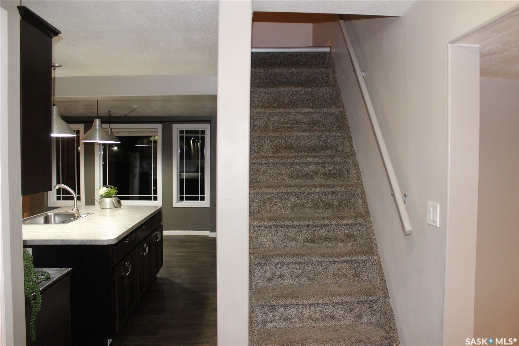 Kitchen with dark wood-finish cabinetry, light-toned countertop, and stainless steel undermount sink
