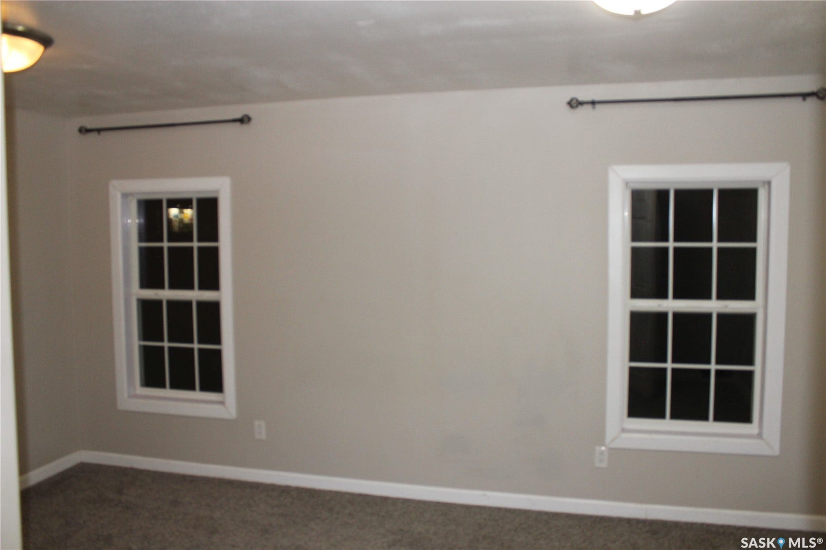 Neutral tone wall paint, white window trim, and wall-to-wall carpeting