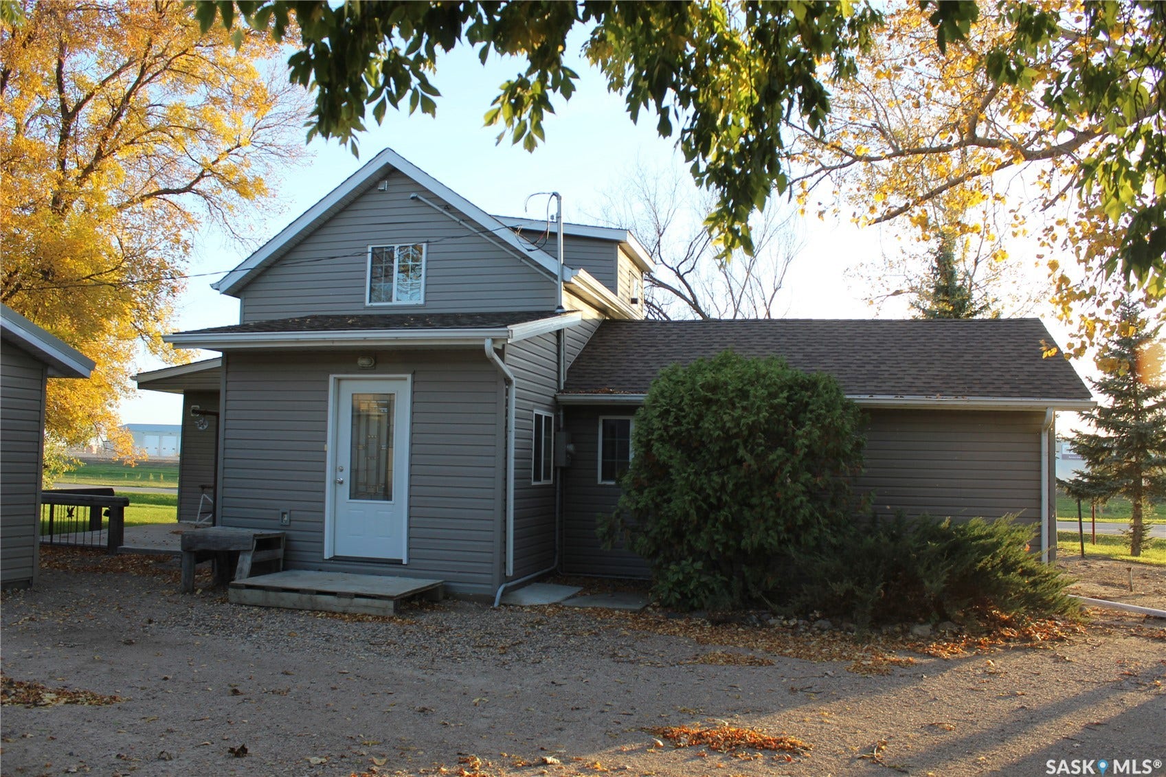 Gray siding exterior with multiple windows and a white entry door