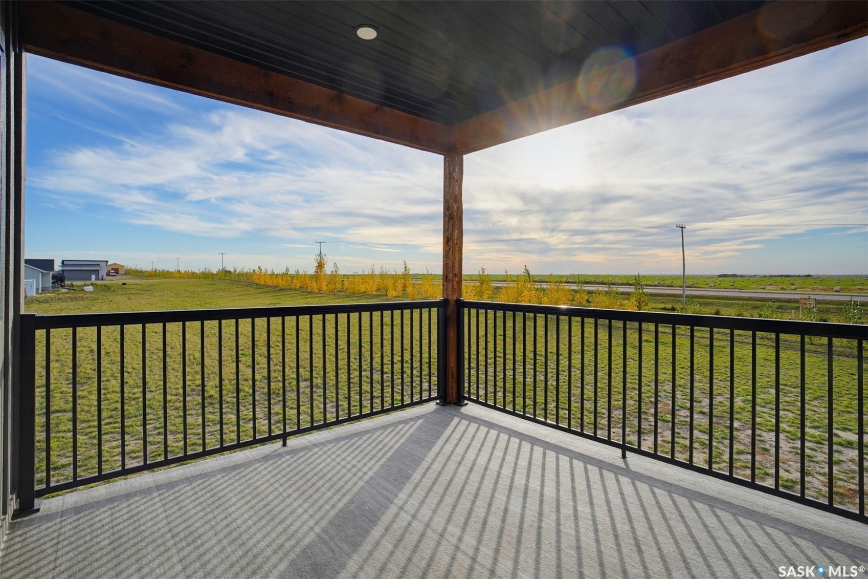 Covered outdoor living space featuring dark wood-finish ceiling, recessed lighting, and black metal railings
