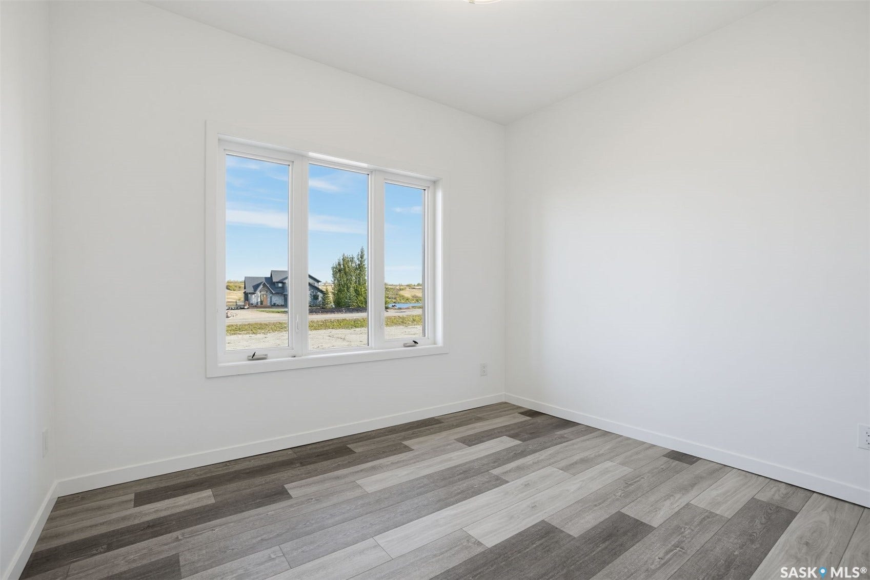 Neutral wall paint, wood-finish flooring, and a multi-pane window