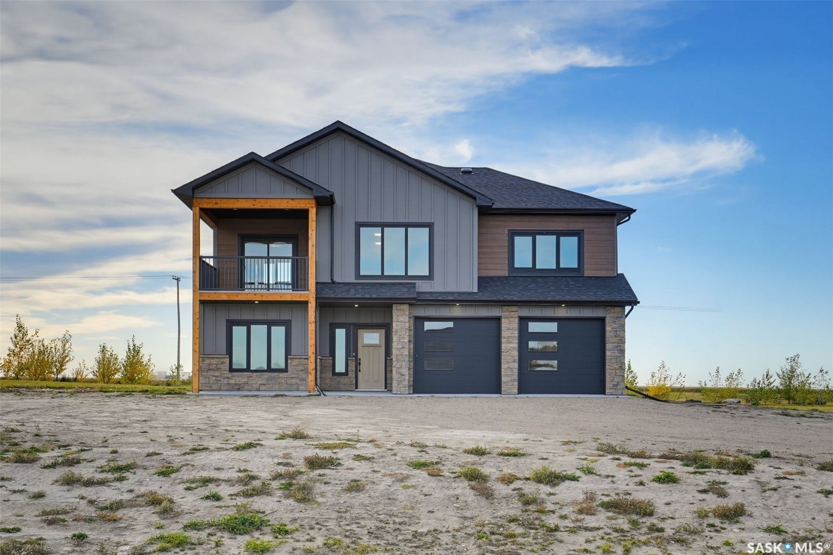 Contemporary exterior with mixed material siding, stone accents, and a covered balcony