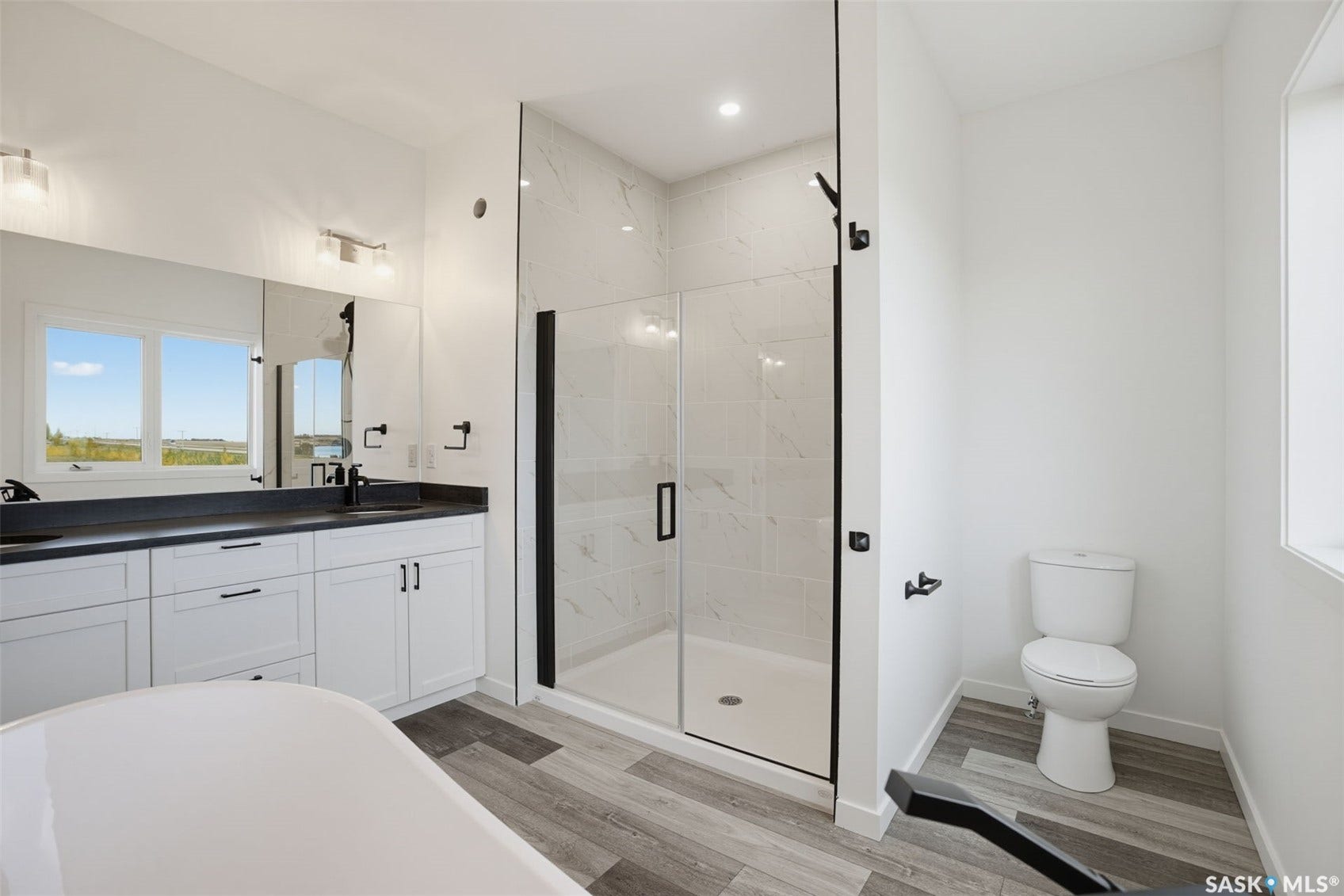 Dual vanity with white cabinetry, dark countertops, and matte black fixtures