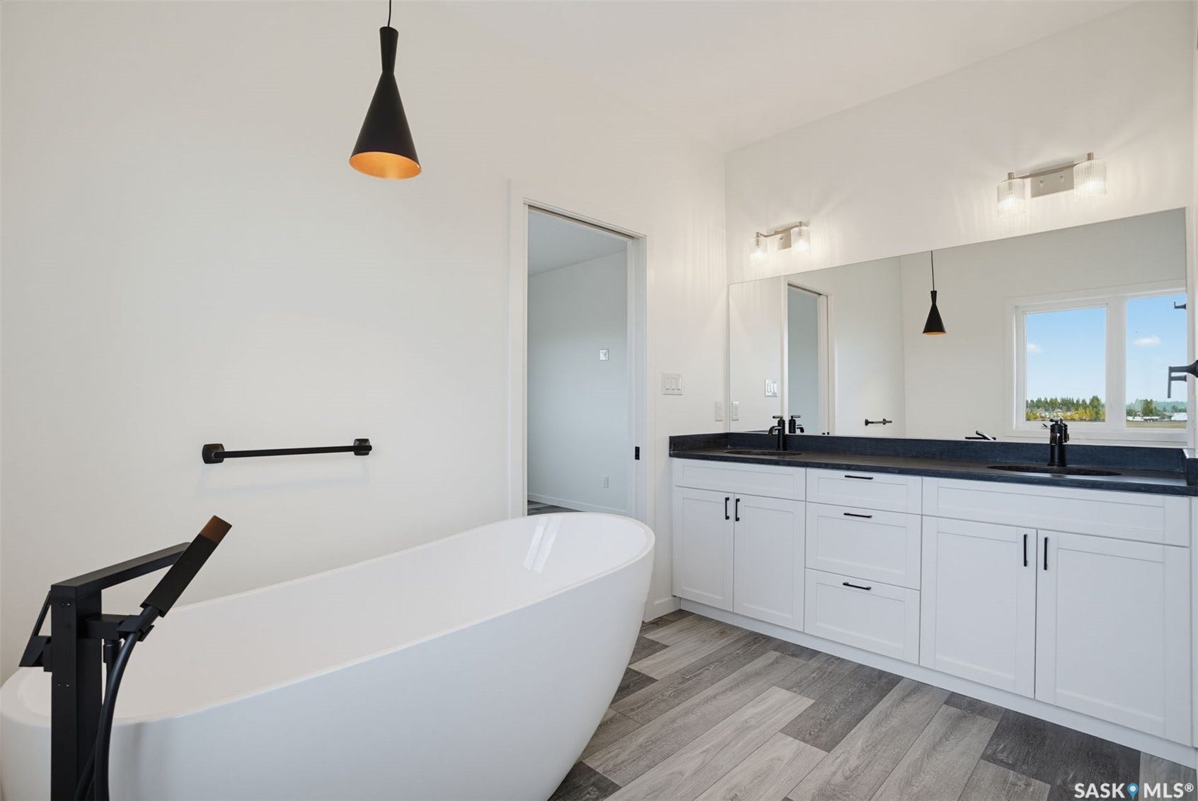 Freestanding soaking tub with a floor-mounted matte black faucet