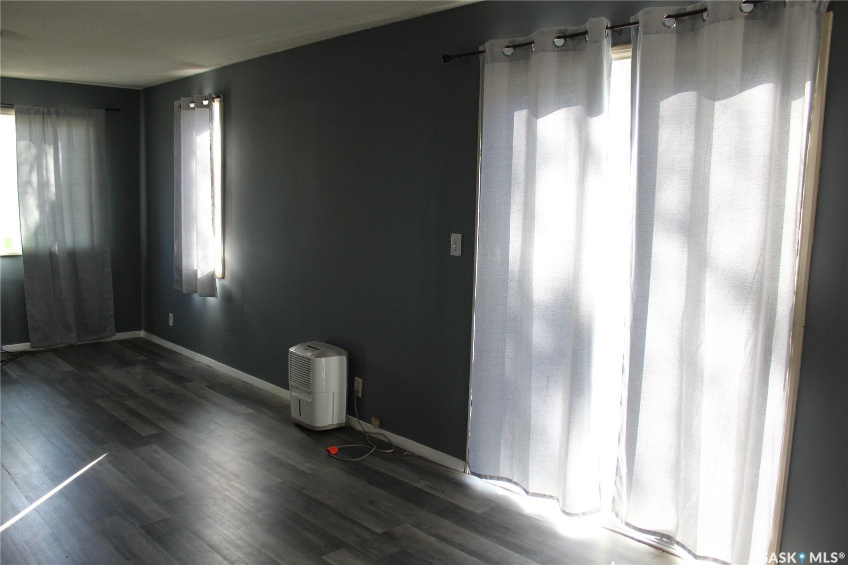 513 2nd Street W, Wilkie SK S0K 4W0 Wood-finish flooring, dark-painted walls, and natural light from multiple windows