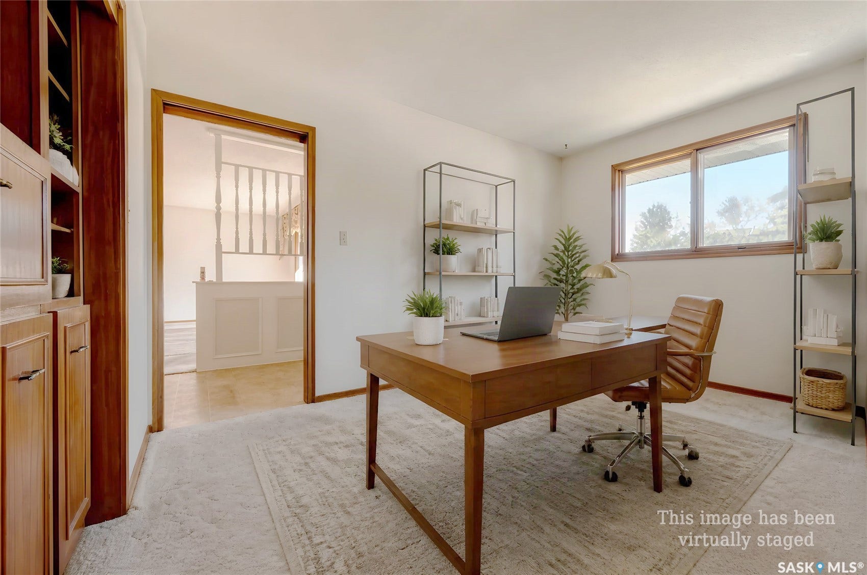Built-in wood cabinetry with metal pulls, wood-framed window, and neutral wall color