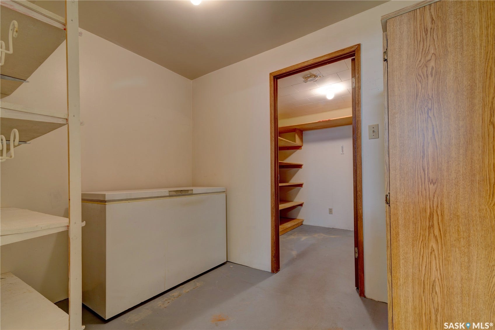 Interior room with shelving units and a wood-finish door