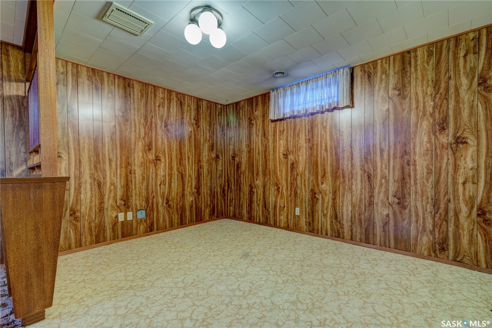 Wood-finish paneling, patterned carpeting, recessed window, and flush-mount ceiling light