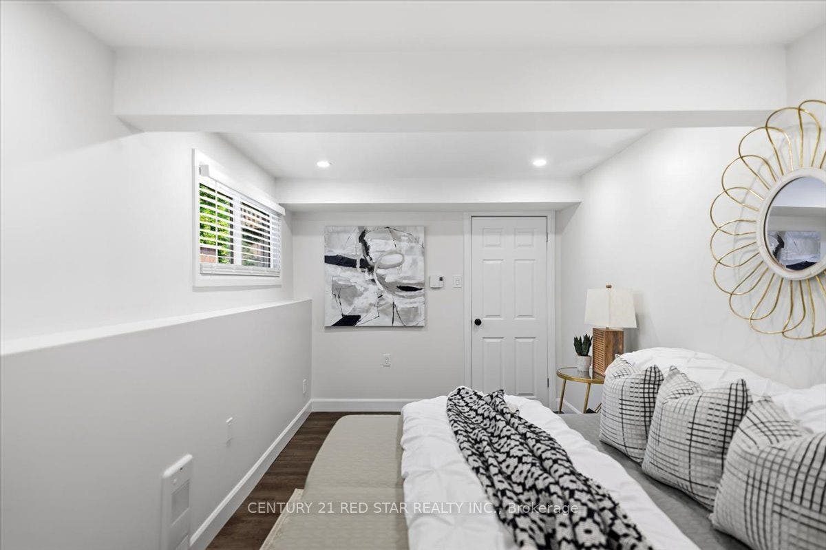 Large window in basement bedroom with king bed