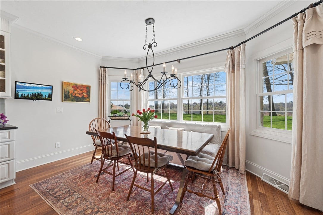 eating area filled with natural light from the surrounding windows over looking the level back yard