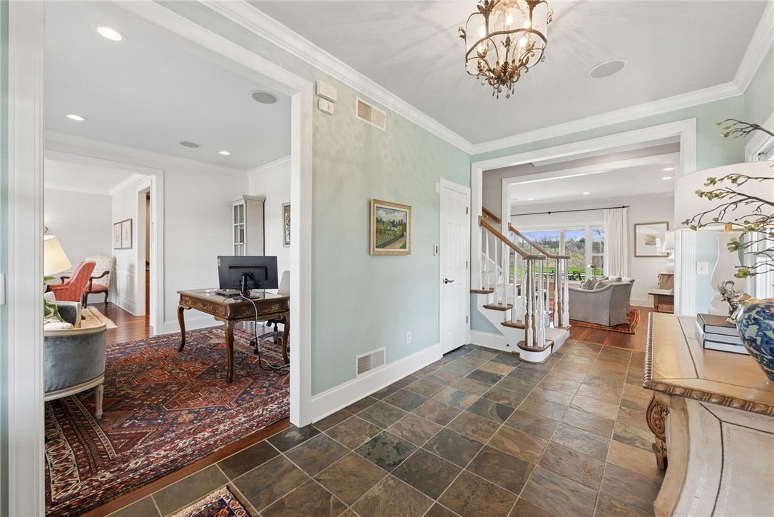 front entry with natural slate tiled floor with a view into the den and the living room